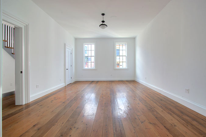 Living room with hardwood floors and white walls overlooking Union Street