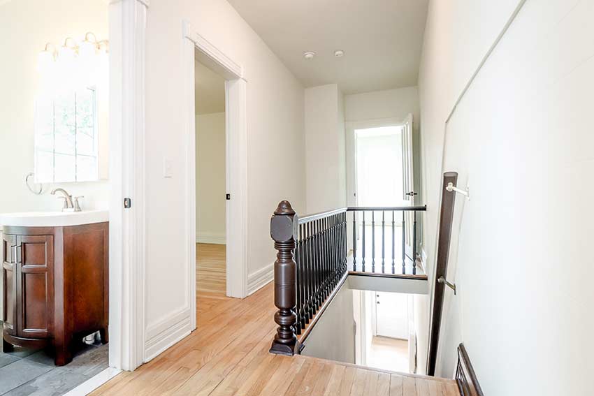 Hallway at the top of stairs, bathroom on left.