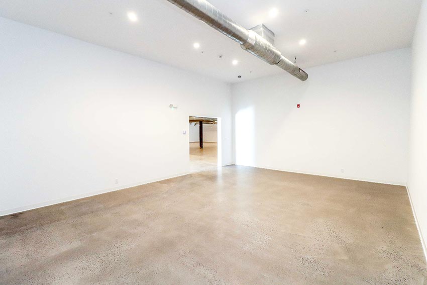 Open room with concrete floors and exposed HVAC ductwork.