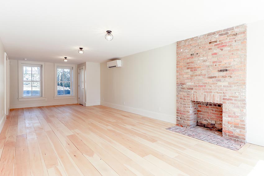 Wide open light-filled space with wood burning fireplace on ground floor