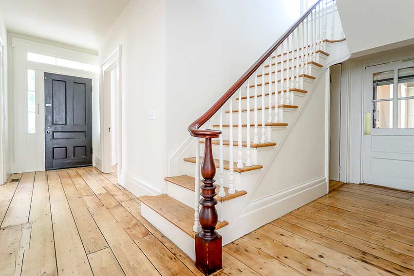 Front entrance with stairs to second floor and front porch door on the right.