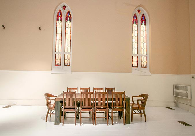 Dining table in front of large stained glass windows