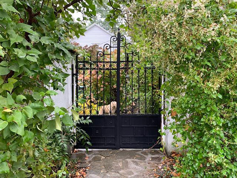 Decorative gate on stone covered walkway to house
